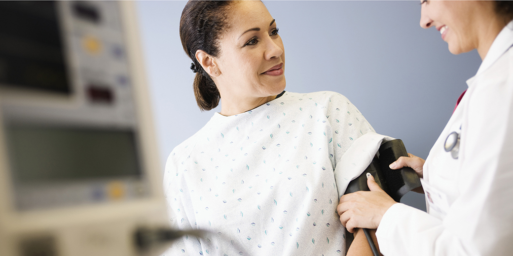 woman at doctor appointment with blood pressure cuff